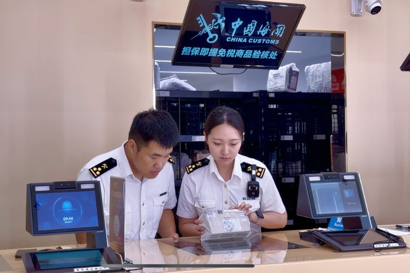 压_【配图】三亚机场海关关员在三亚凤凰机场对担保即提免税商品开展验核